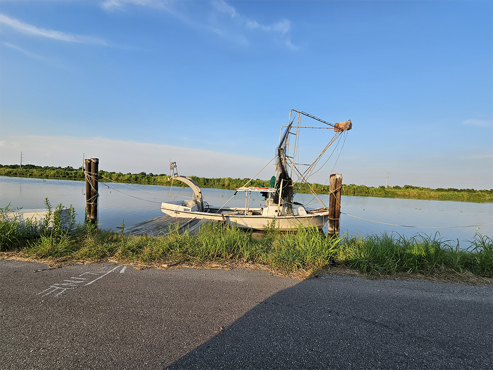 湿地の水路に停泊する小さなエビ漁船